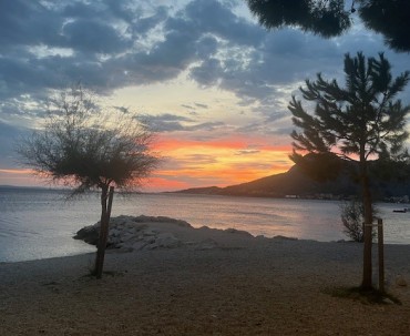 Malowniczy zachód slońca na plazy w Omisu